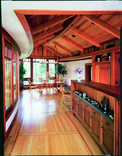 The house’s radial lines are reflected in the curving soffit and ridge beam. A local furniture maker created the dining room table and chairs using native black oak and pine from the property